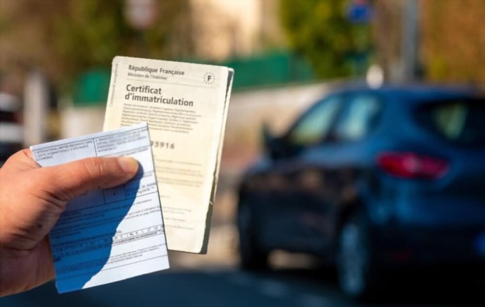 Homme tenant dans sa main une carte grise de véhicule